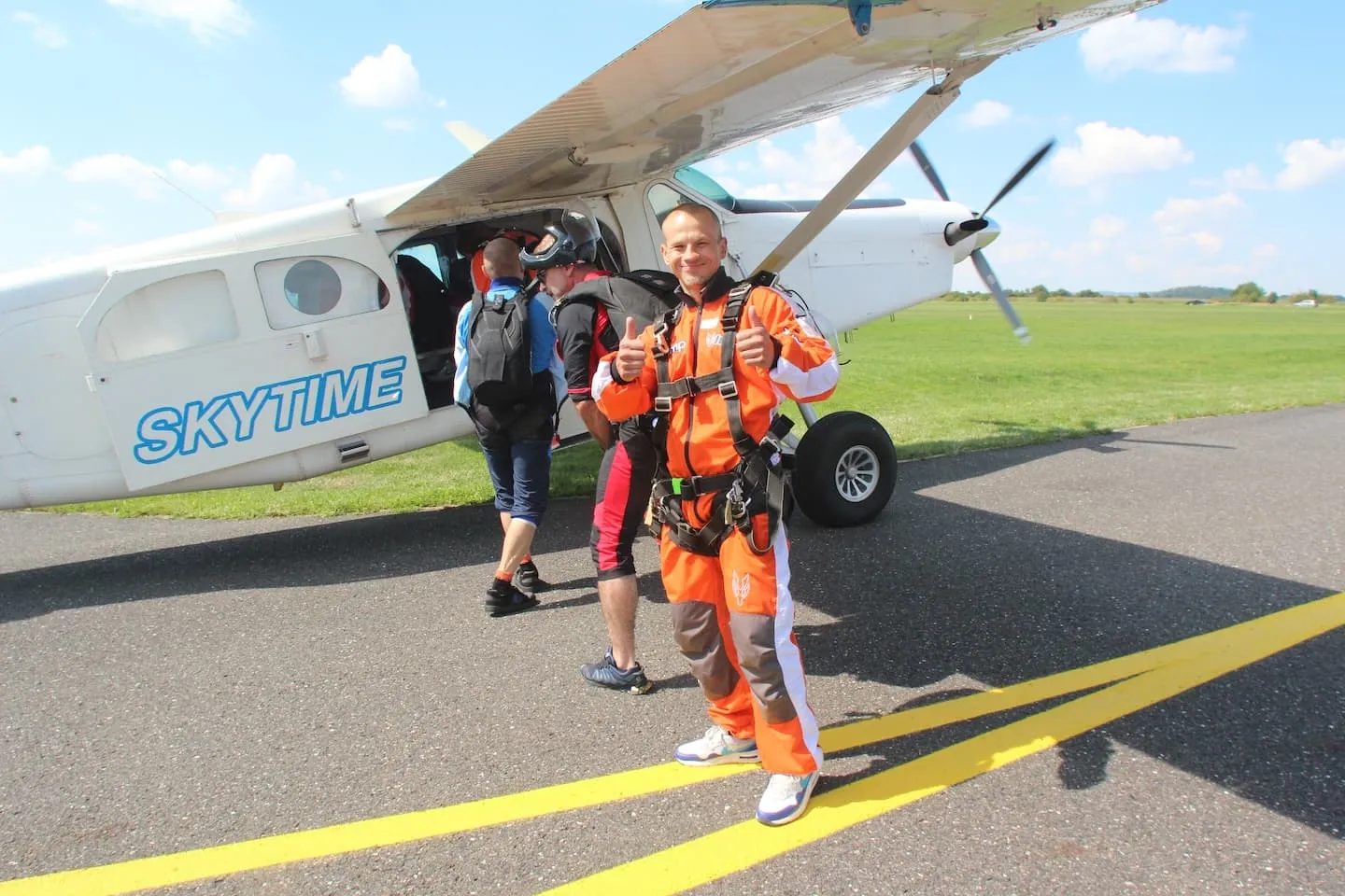 Tandemmaster mit Passagier beim Einsteigen ins Flugzeug