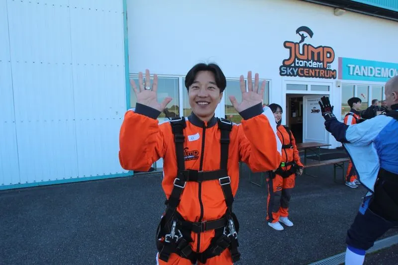Mann vor dem Flugplatz in Příbram mit dem Jump-Tandem-Logo