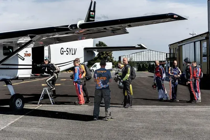 Tandemmaster und Passagiere beim Einsteigen ins Flugzeug