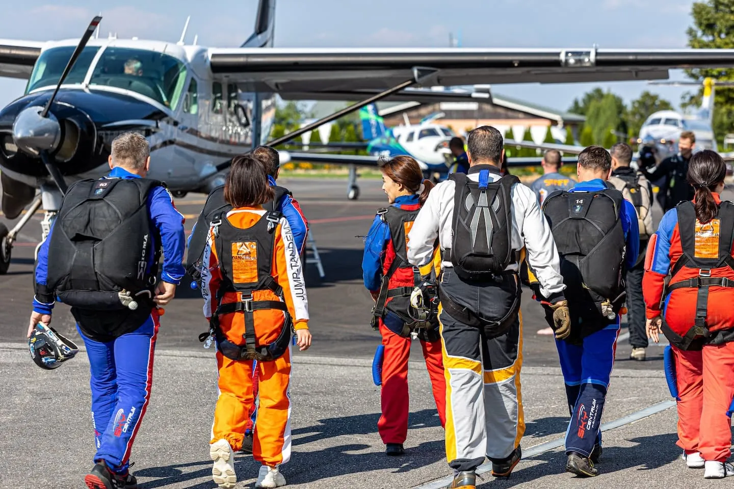 Tandemmaster und Passagiere vor dem Einsteigen ins Flugzeug