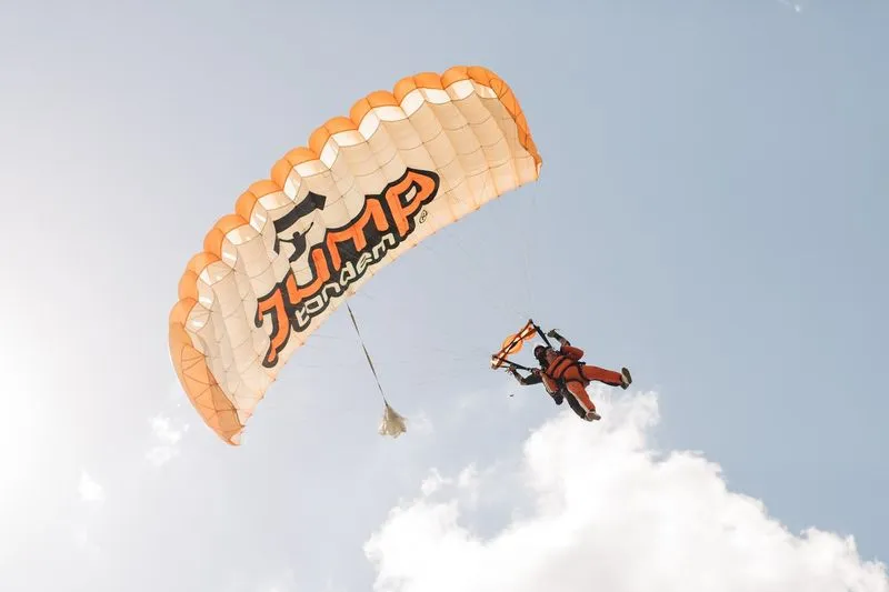 Instructor tándem con un pasajero volando en paracaídas