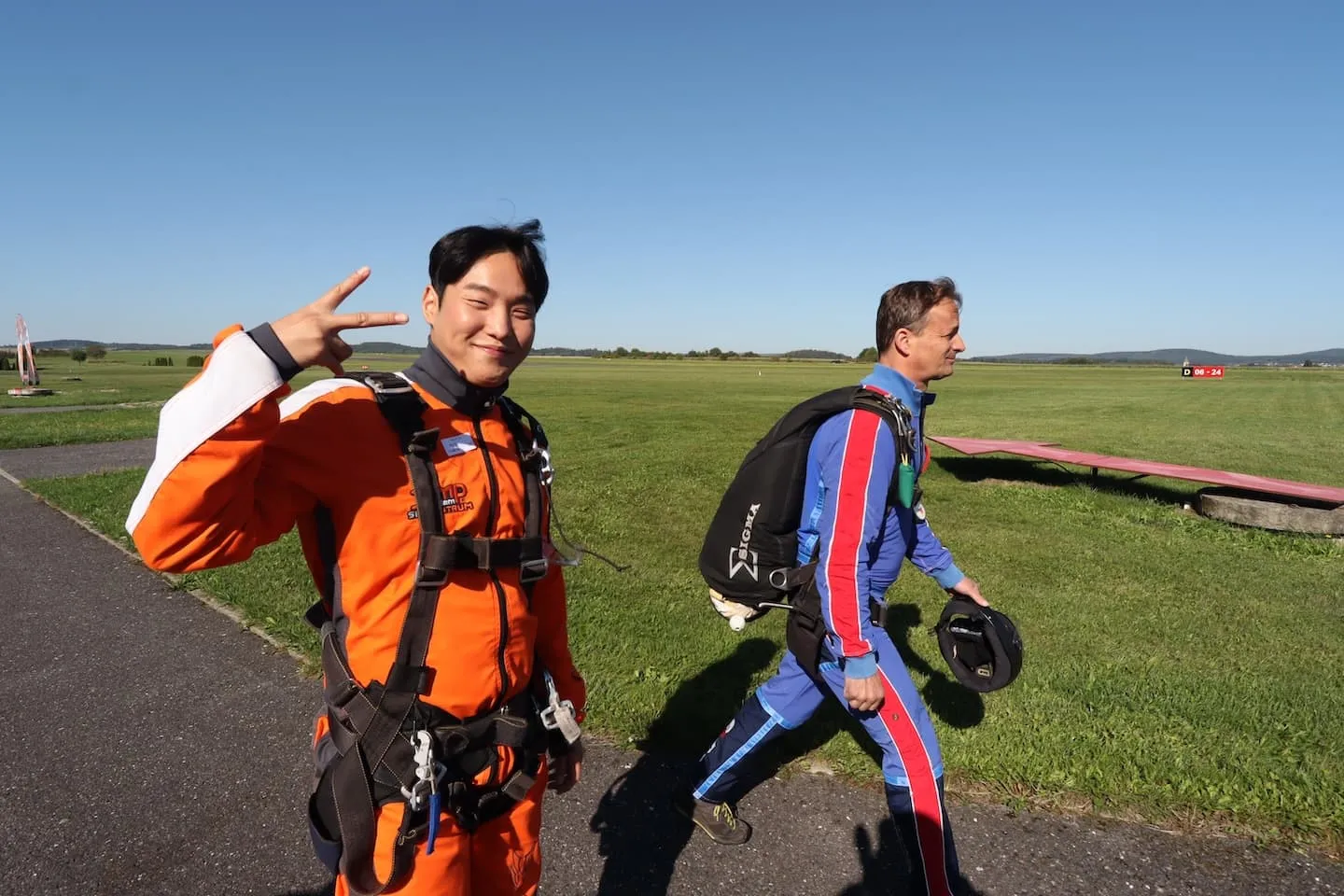 Tandemmaster mit Passagier vor dem Einsteigen ins Flugzeug