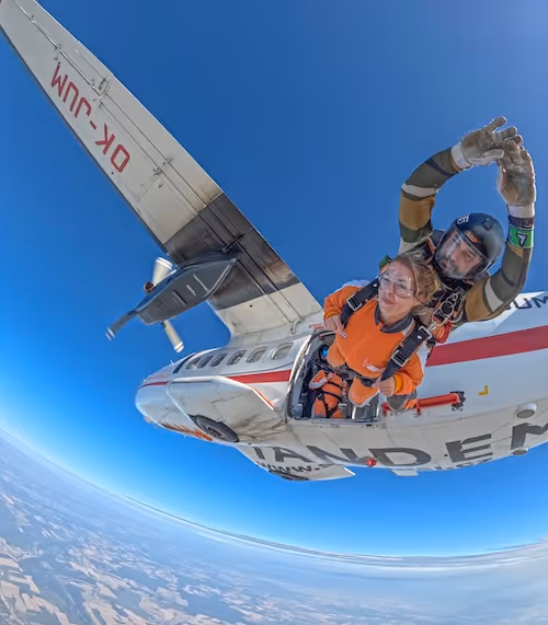 Zwei Personen springen aus dem Flugzeug, bereit für den Tandemsprung
