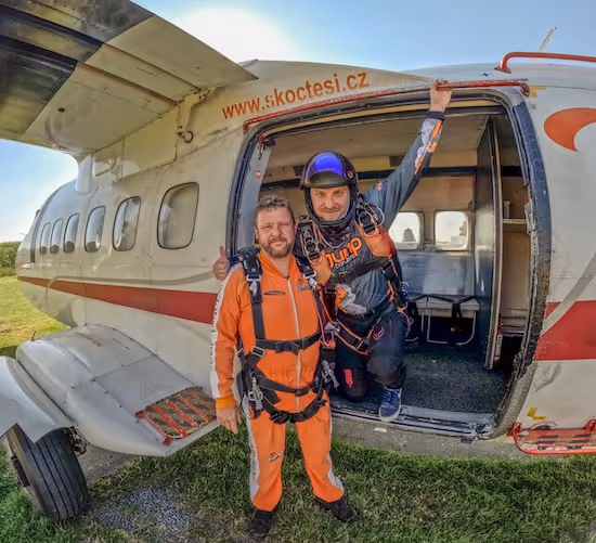 instructor tándem y pasajero tándem en tierra delante de un avión