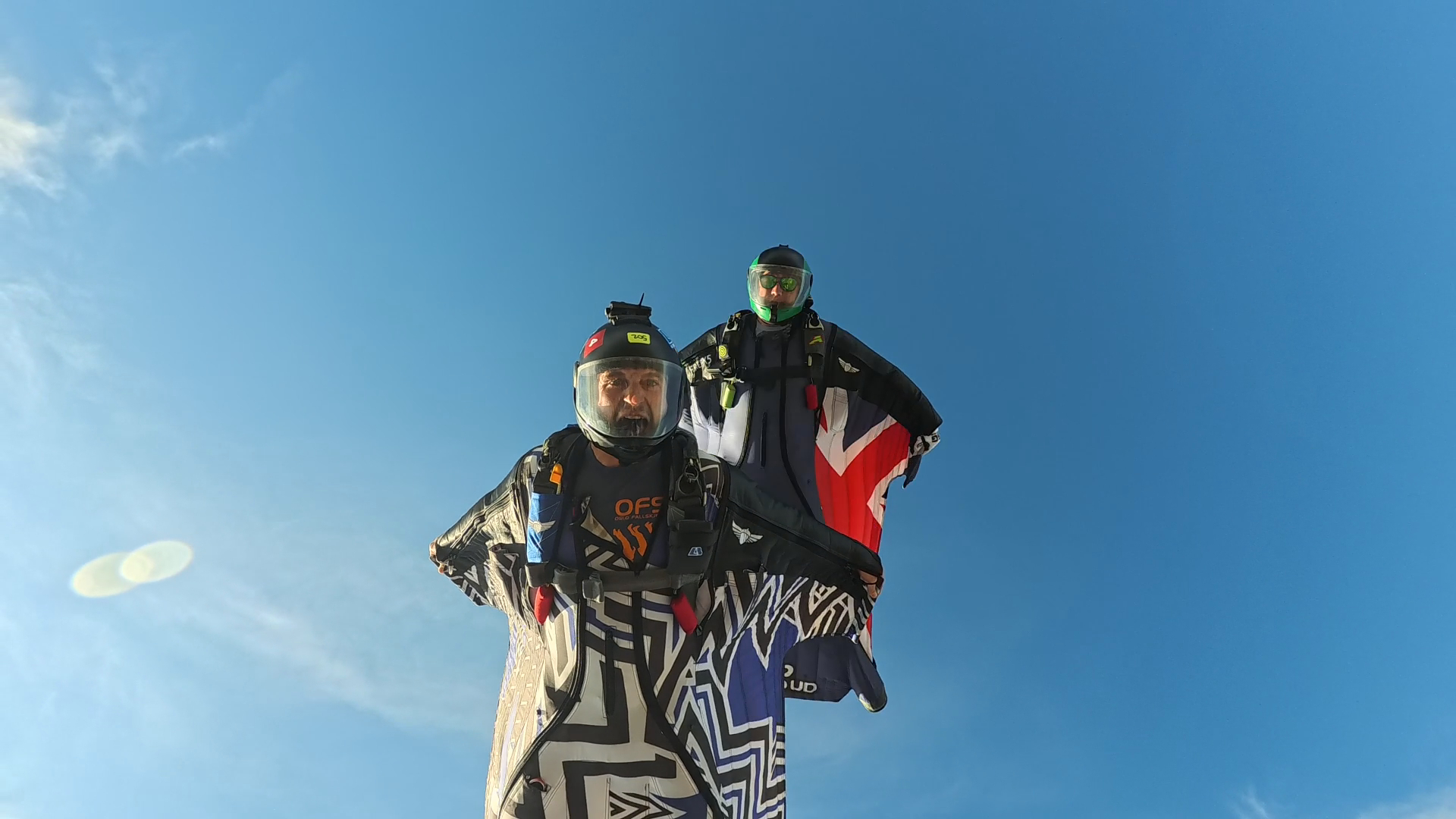 wingsuiteurs dans les airs regardant la caméra